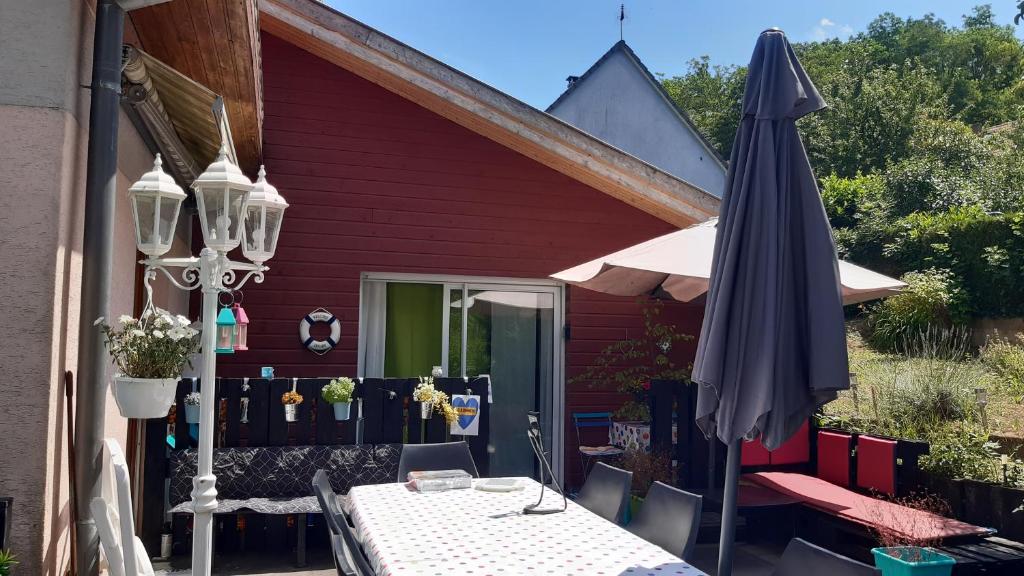 una mesa y una sombrilla en el patio en Ravissant studio dans un cadre agréable en Soultz-Haut-Rhin
