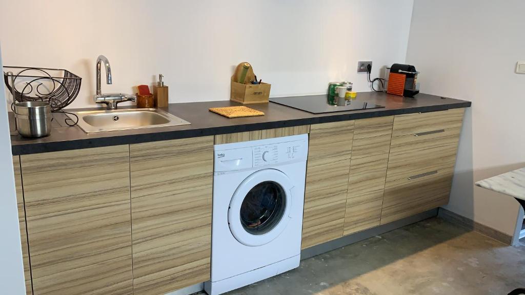 a kitchen with a washing machine and a sink at Studio de Nini in Rousson