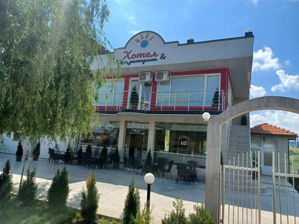 un edificio con mesas y sillas delante de él en Gazi en Popovo