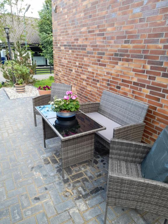 un patio con 2 sillas y una mesa con flores. en Locken1, en Altenau