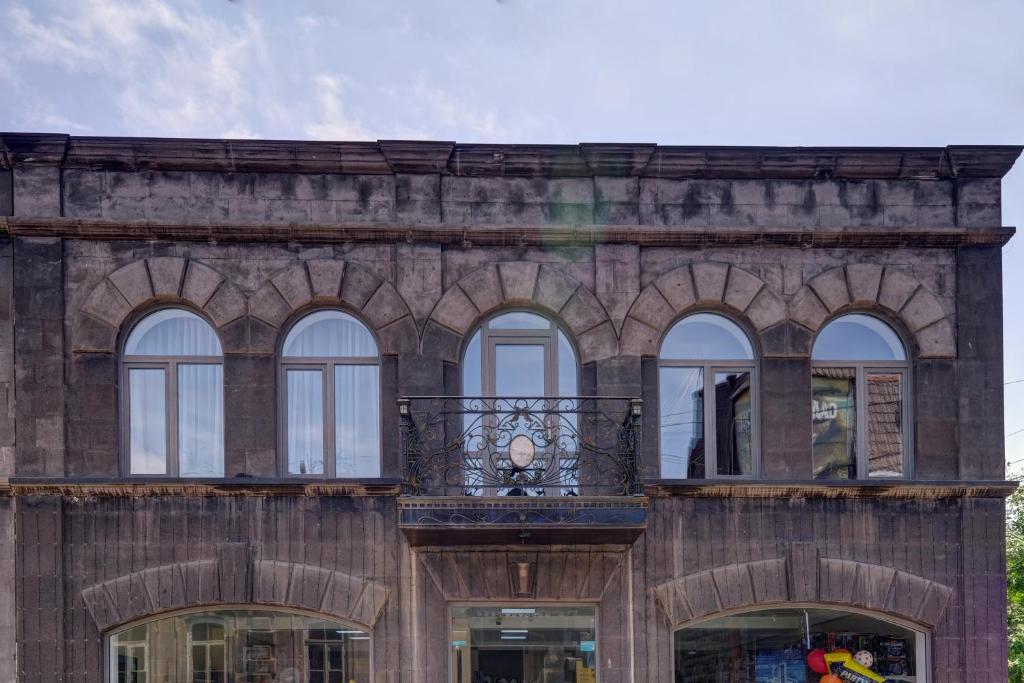 budynek z łukowymi oknami i balkonem w obiekcie Hotel SESIL w mieście Giumri
