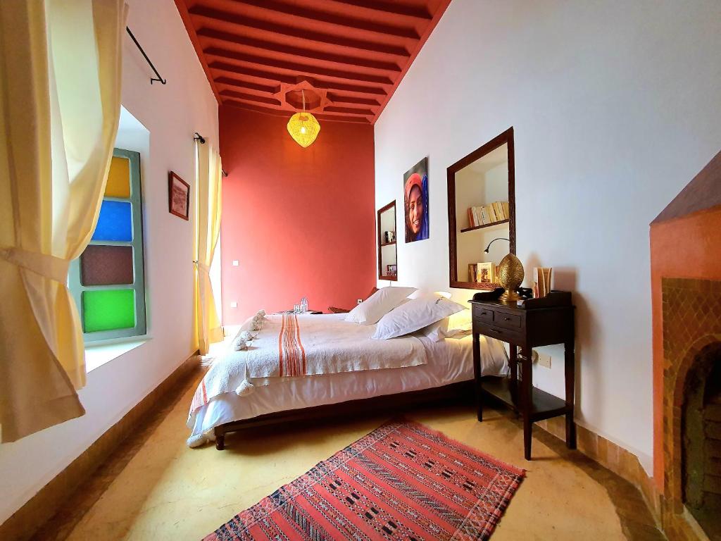 une chambre avec un lit et un mur rouge dans l'établissement Riad Dar Zouar & Spa, à Marrakech 106 autres photos