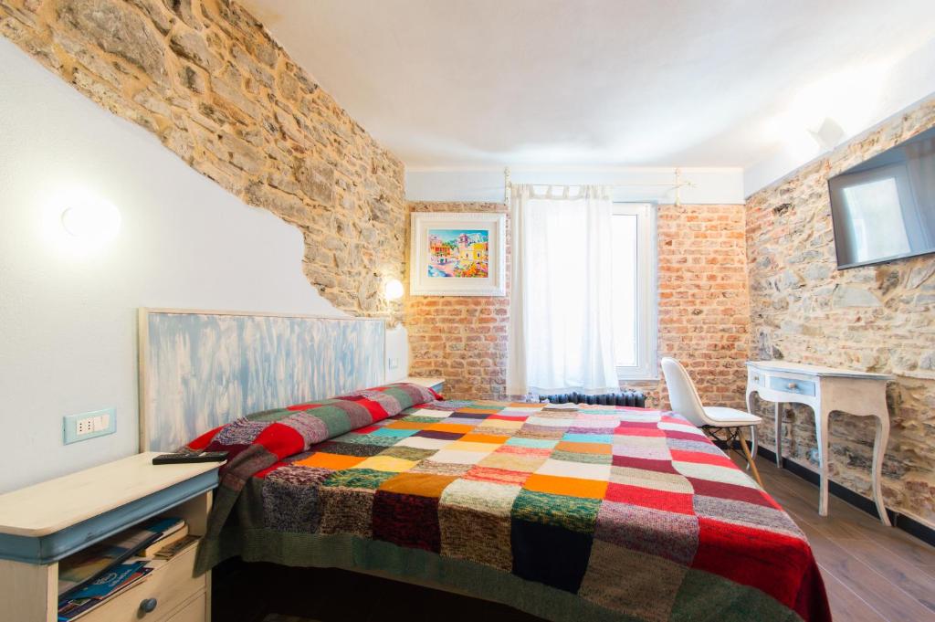 リオマッジョーレにあるCà Della Vallettaのレンガの壁、ベッドルーム1室(ベッド1台、デスク付)