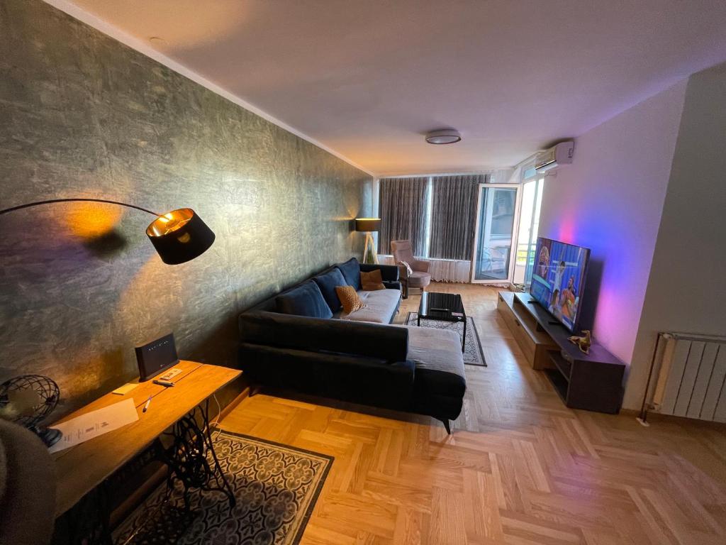 - un salon avec un canapé et une télévision dans l'établissement Korzo Osijek 2, à Osijek