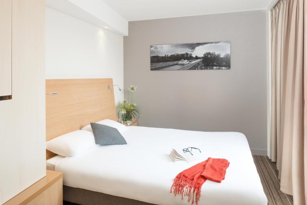 Una cama o camas en una habitación de Aparthotel Adagio Toulouse Centre Ramblas