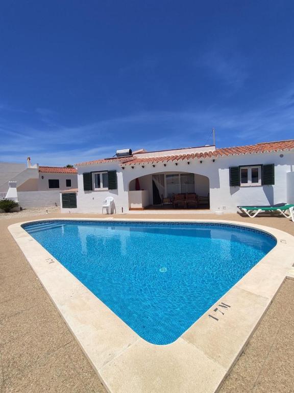 a swimming pool in front of a house at Villa Coral in Cala en Porter