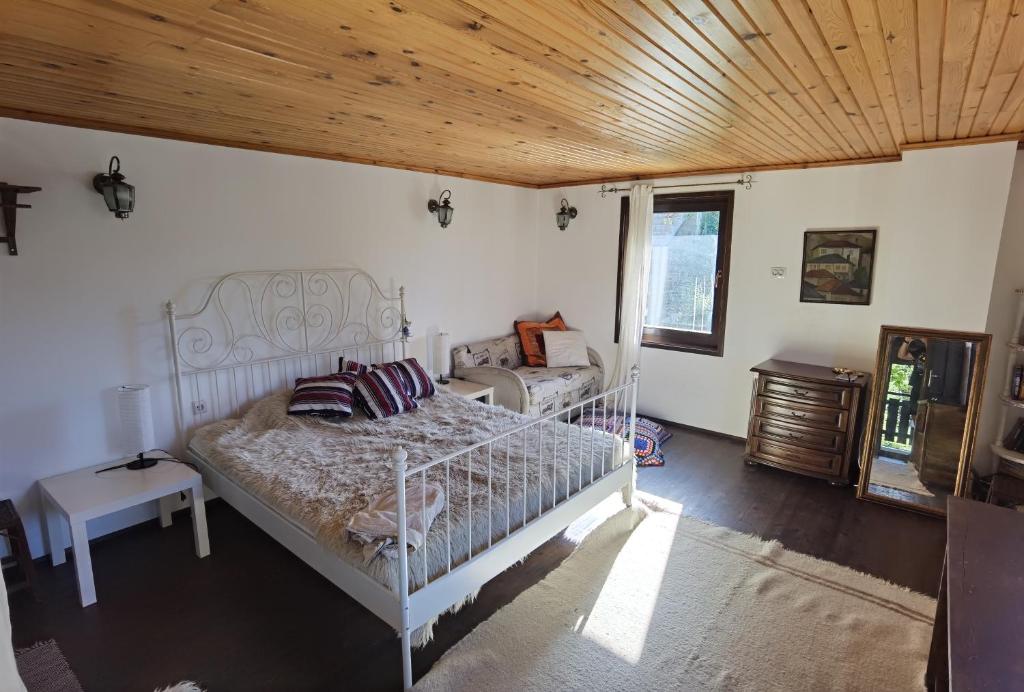 1 dormitorio con cama blanca y techo de madera en Room for guests, en Smolyan