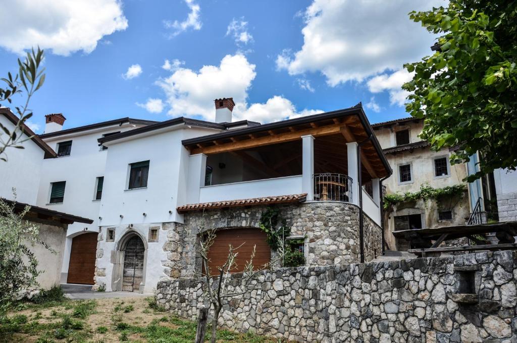 an exterior view of a house with a stone wall at Apartmaji Tanto Malovše in Črniče