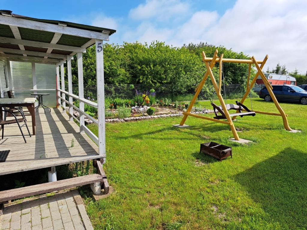 a yard with a swing set and a porch at Mobilūs nameliai 'Zelma' in Palanga