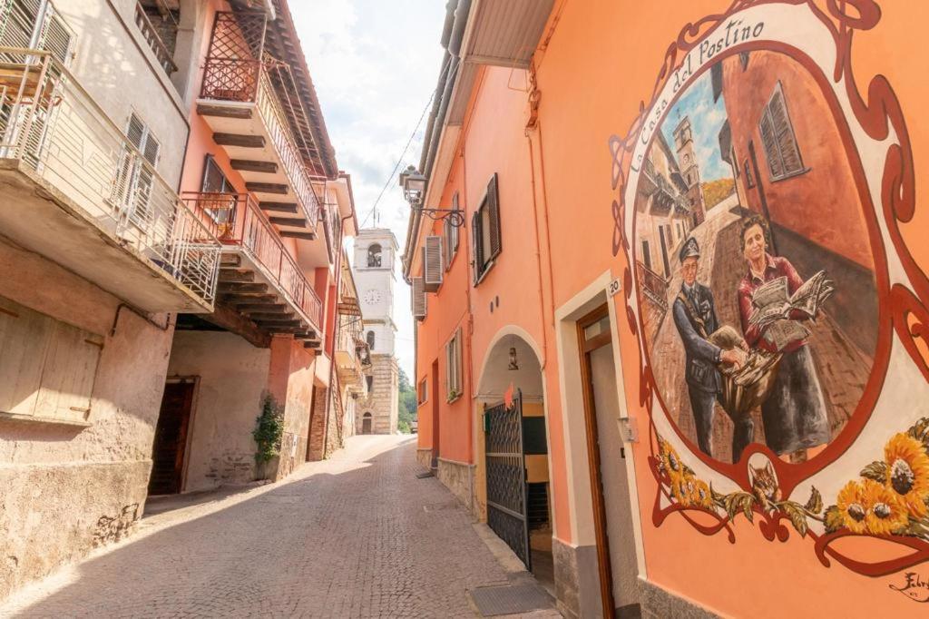 un vicolo con un dipinto sul lato di un edificio di La Casa del Postino a Farigliano