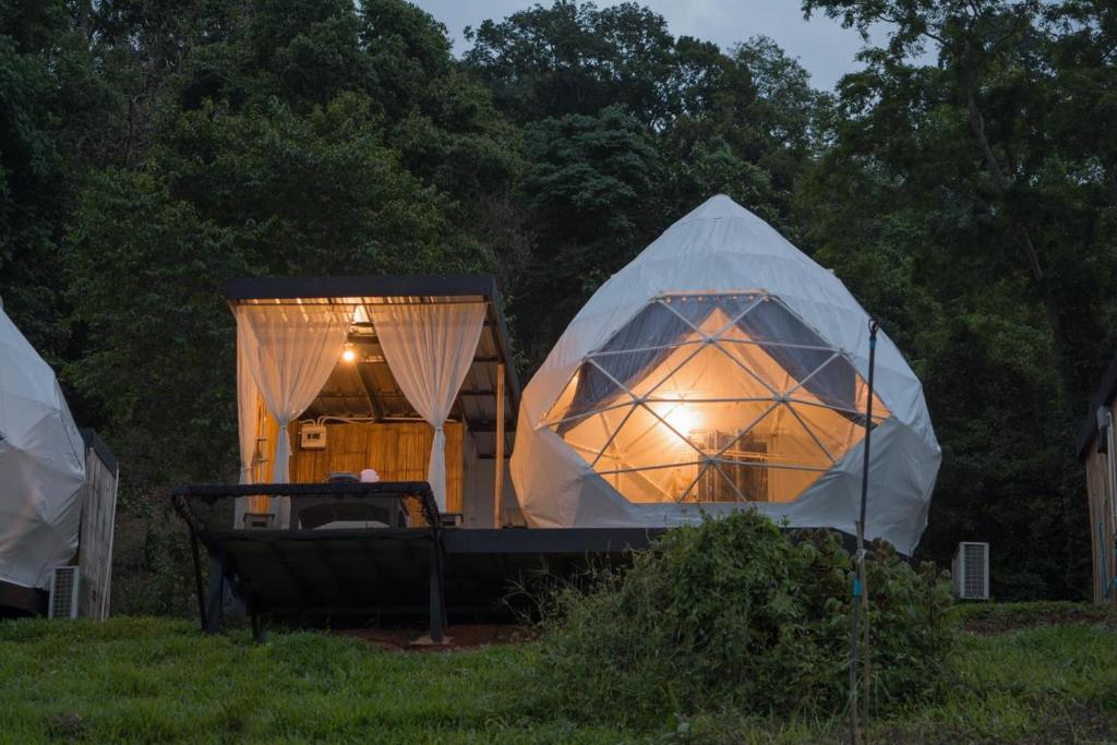 Ban Kai Noi的住宿－หุบเขาโฮมสเตย์，几顶帐篷,草地上有一张床
