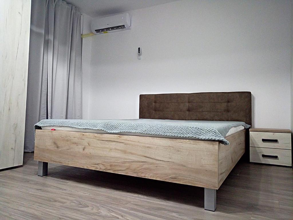 a bedroom with a bed with a wooden bed frame at Garsoniera Angelica in Sulina