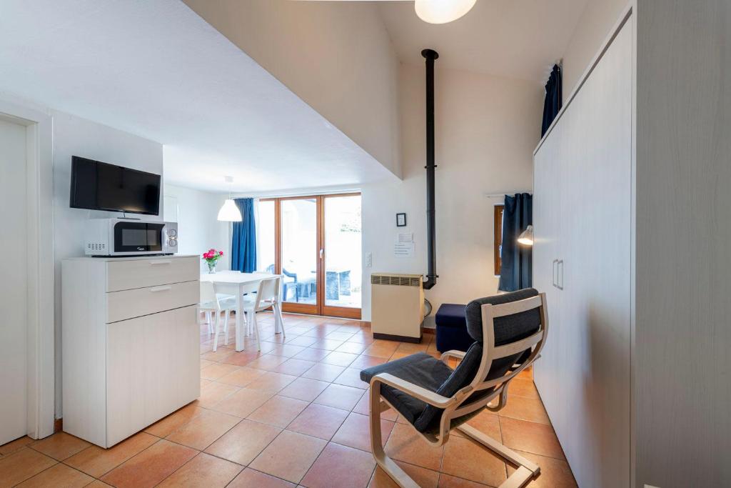a kitchen and a living room with a chair and a table at I Grappoli in Sessa