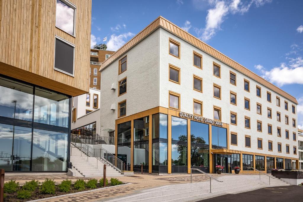 un edificio de oficinas con ventanas de cristal en una calle en Quality Hotel Grand Larvik, en Larvik