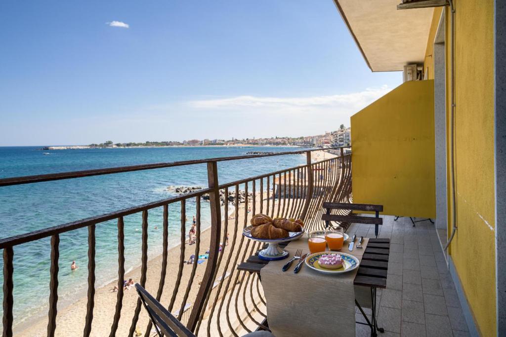 a table on a balcony with a view of the ocean at Loft Panorama di Naxos in Giardini Naxos