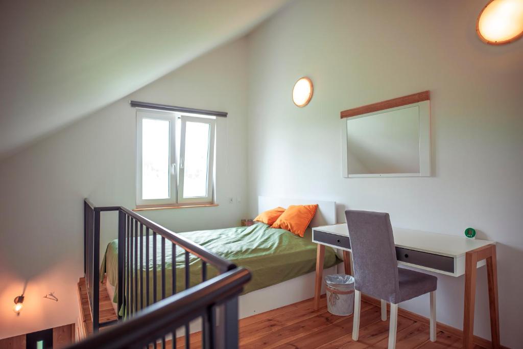 a bedroom with a bed and a desk and a window at Zimna Apartments in Kwidzyn