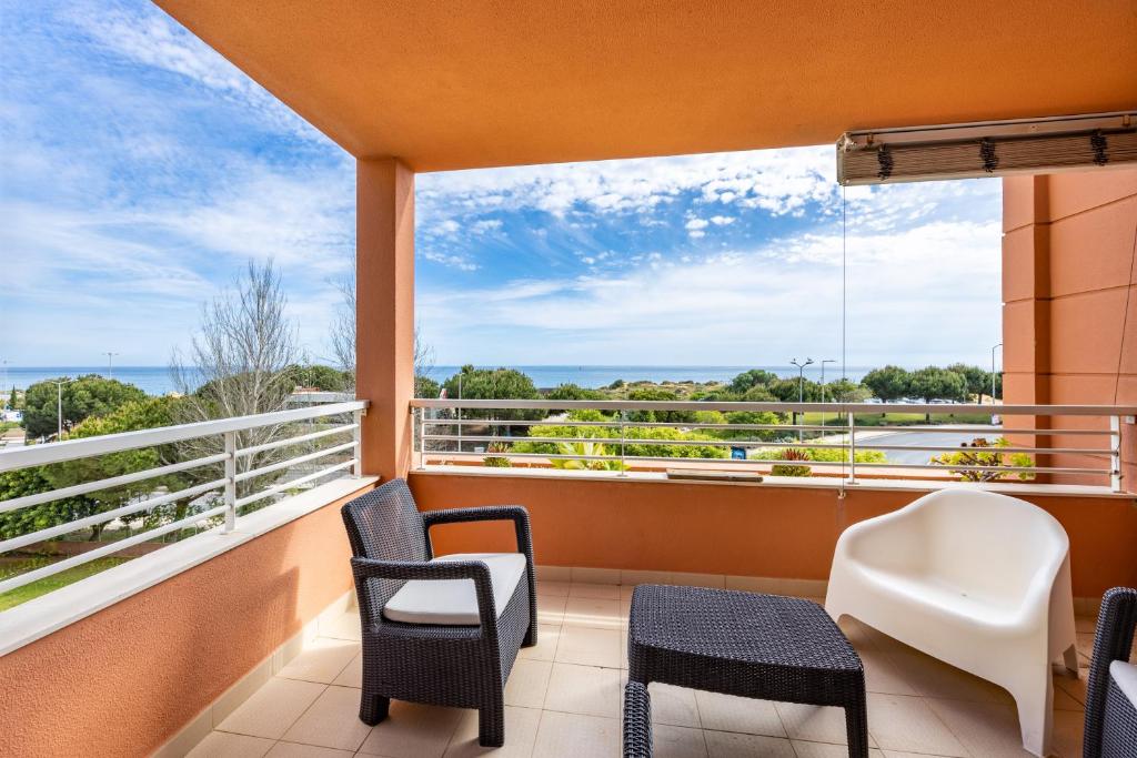 a balcony with chairs and a view of the ocean at Litoral Mar Praia in Portimão