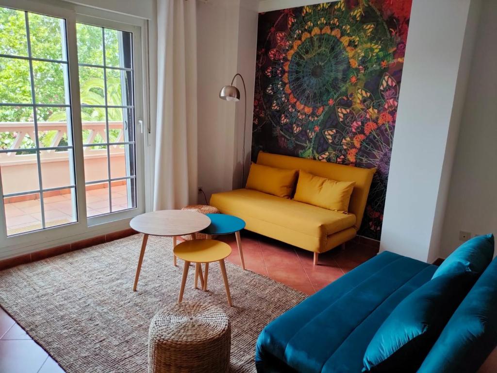 uma sala de estar com um sofá e uma mesa em A charming 6-person apartment, golf, surfing, free tennis courts and bicycles em Isla Canela