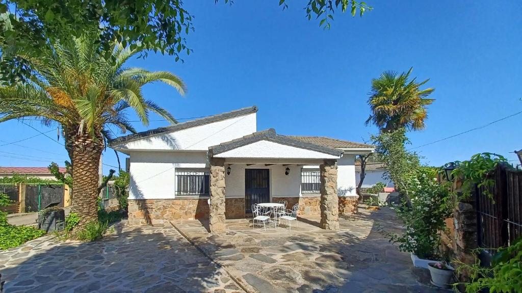 una casa blanca con palmeras delante en Chalet independiente con amplio jardín y barbacoa AT - CC-00678, en Puerto Rey