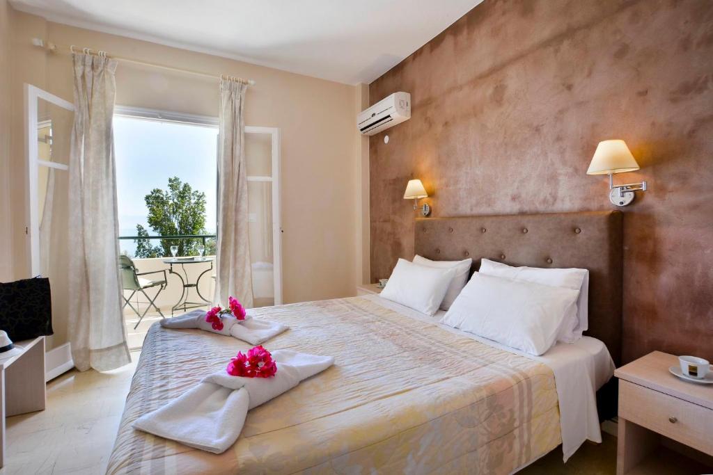 a bedroom with a large bed and a balcony at Veroniki Studios & Apartments in Moraitika