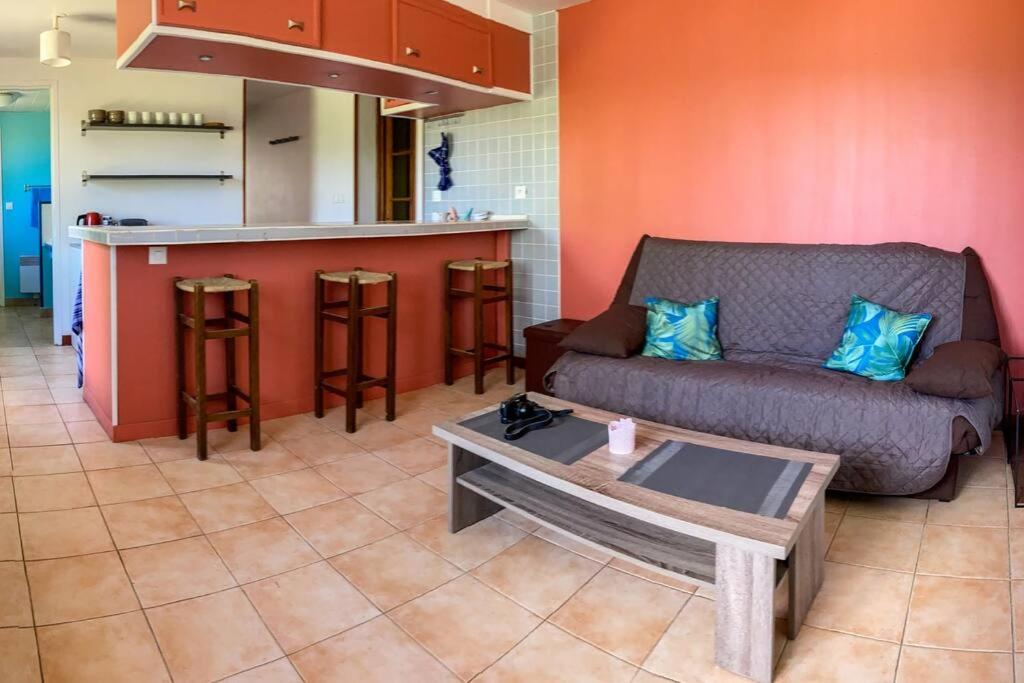 a living room with a couch and a kitchen at maison à Joyeuse sud Ardèche in Joyeuse