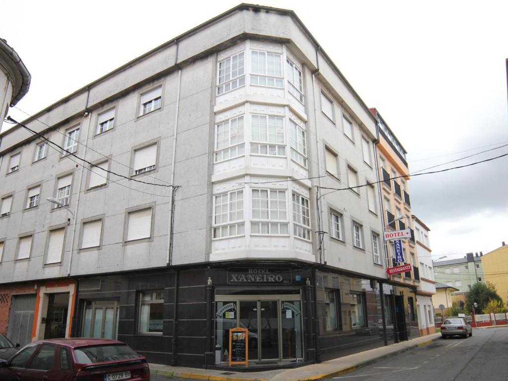 a large white building on a city street at Hotel Restaurante Xaneiro in Melide