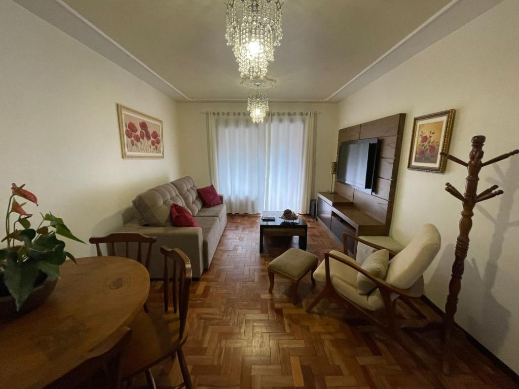 a living room with a couch and a table at Apartamento para 9 pessoas - Blumenhaus 201 - uma quadra da Rua Coberta! in Gramado