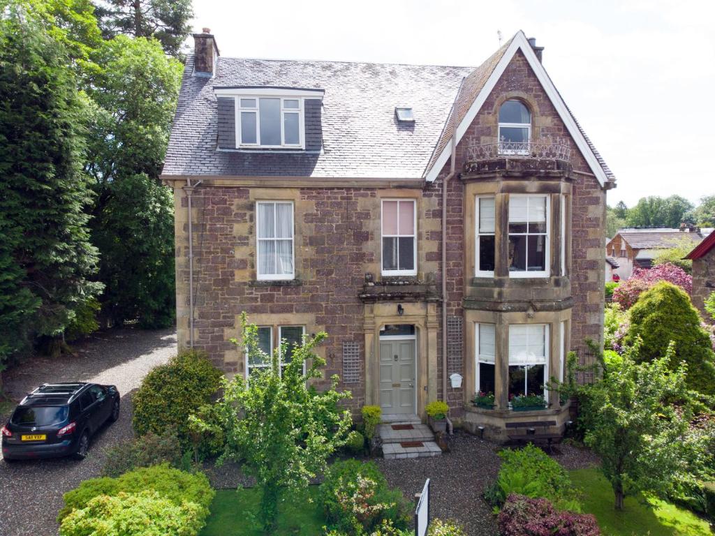 a car parked in front of a brick house at Annfield House, Callander in Callander