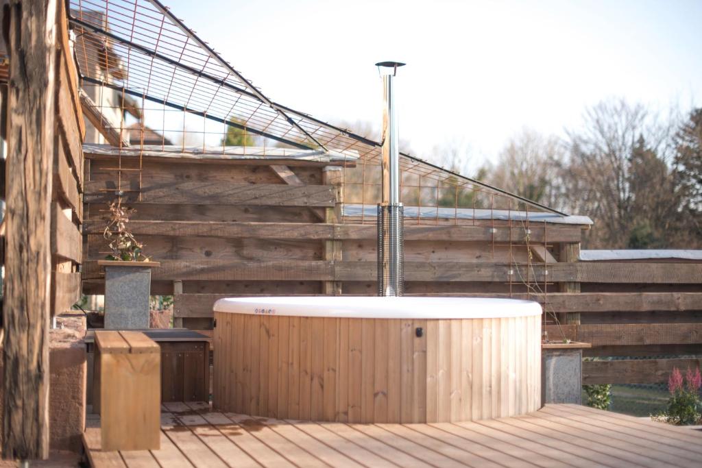 een hot tub op een terras naast een trap bij La Loge du Pic Noir in Dabo