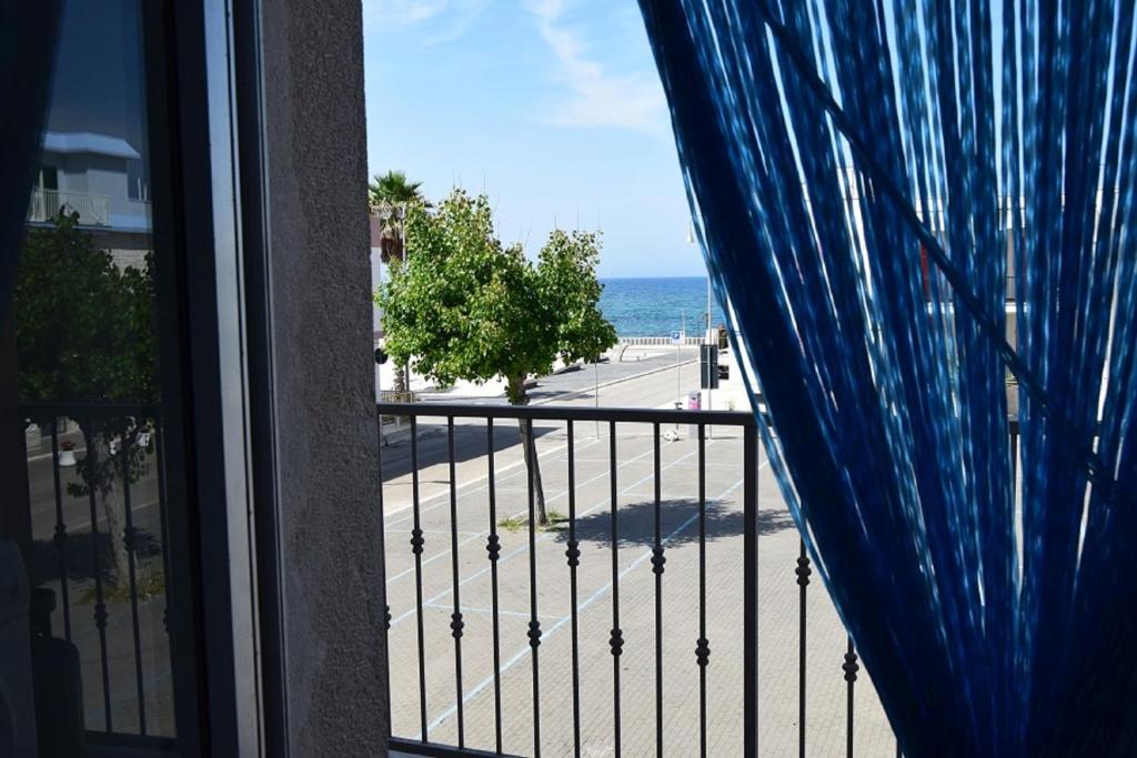 Elle comprend un balcon offrant une vue sur la rue et l'océan. dans l'établissement Appartamento Il Marinaio vista mare - MyHo Casa, à Torre Canne