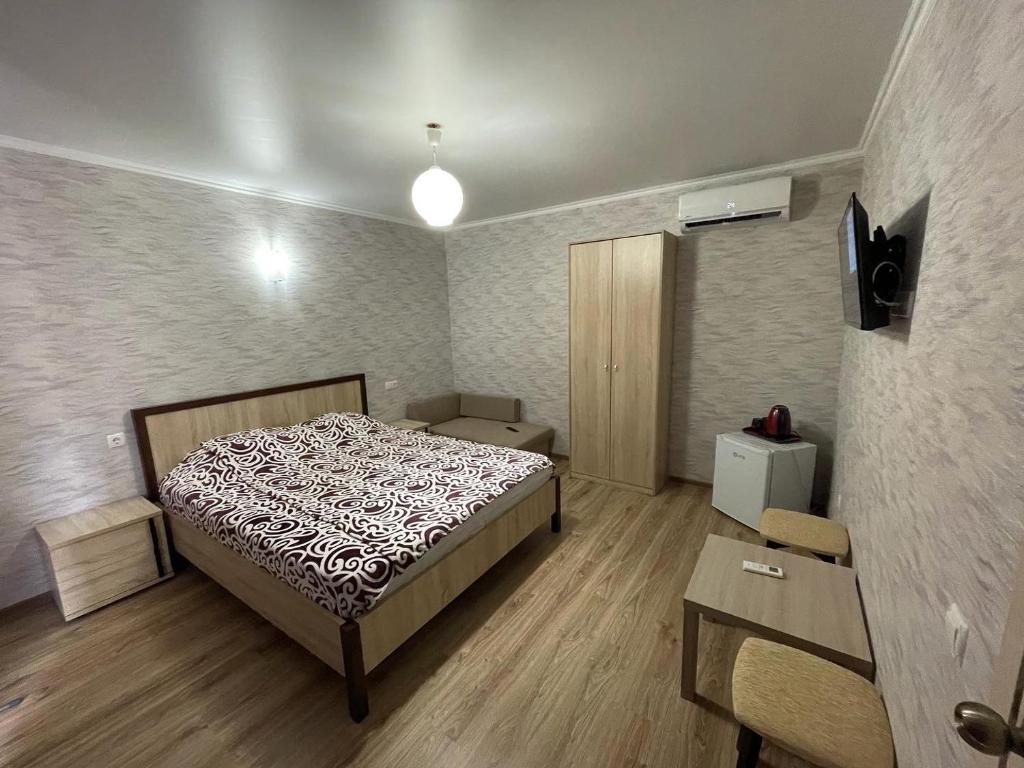 a small bedroom with a bed and a table at RT-Hotel in Novy Afon