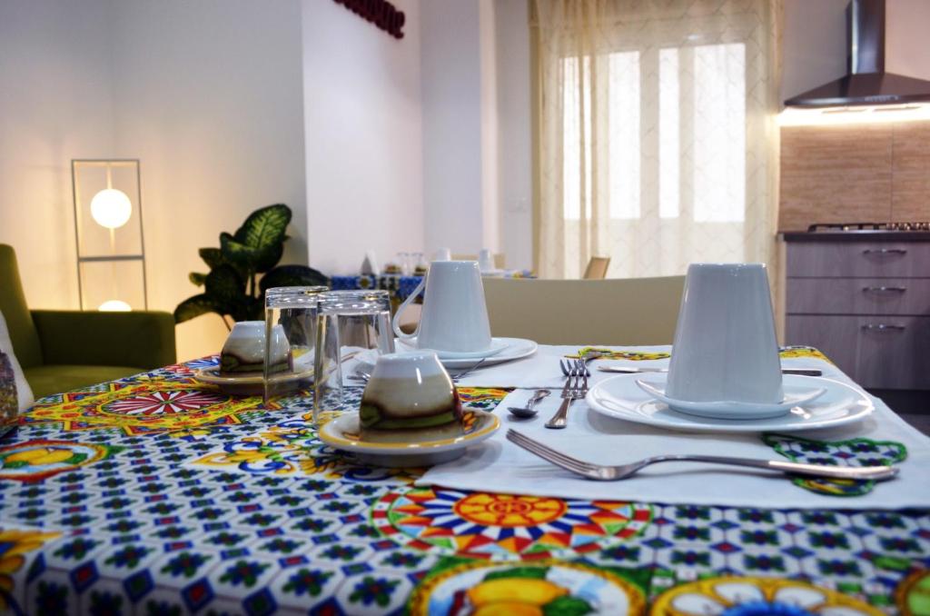 uma mesa com uma toalha de mesa com utensílios em Casa Canali em Palermo