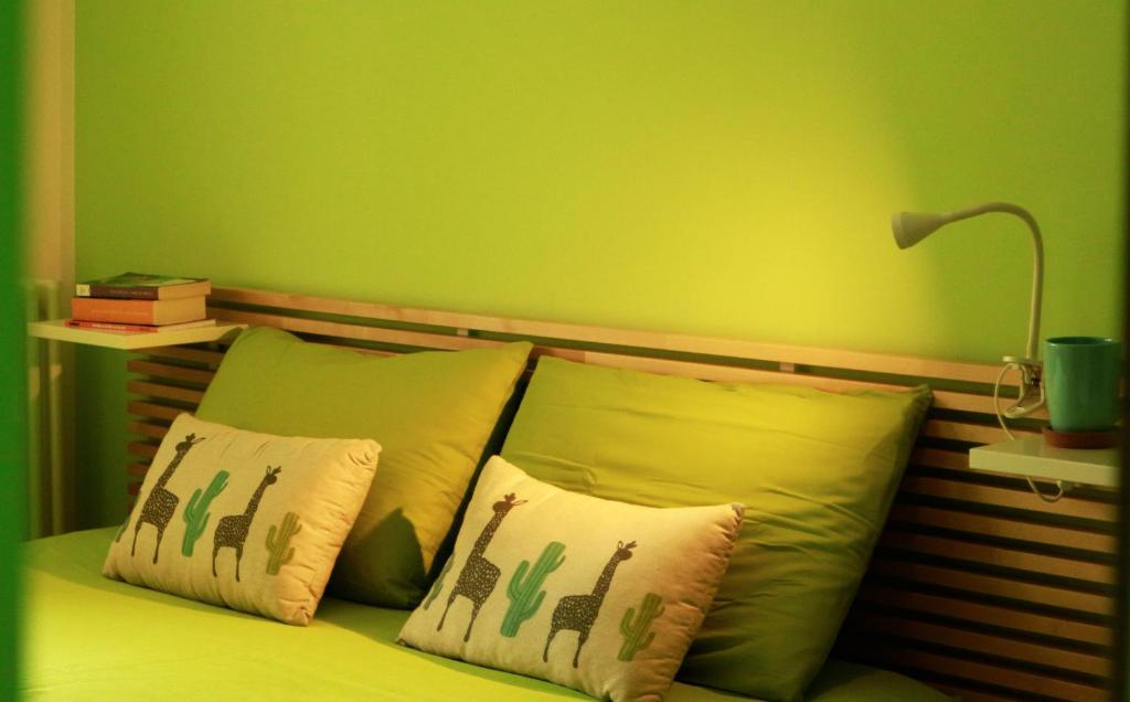 um quarto verde com uma cama com duas almofadas em Sweet Home em LʼAquila