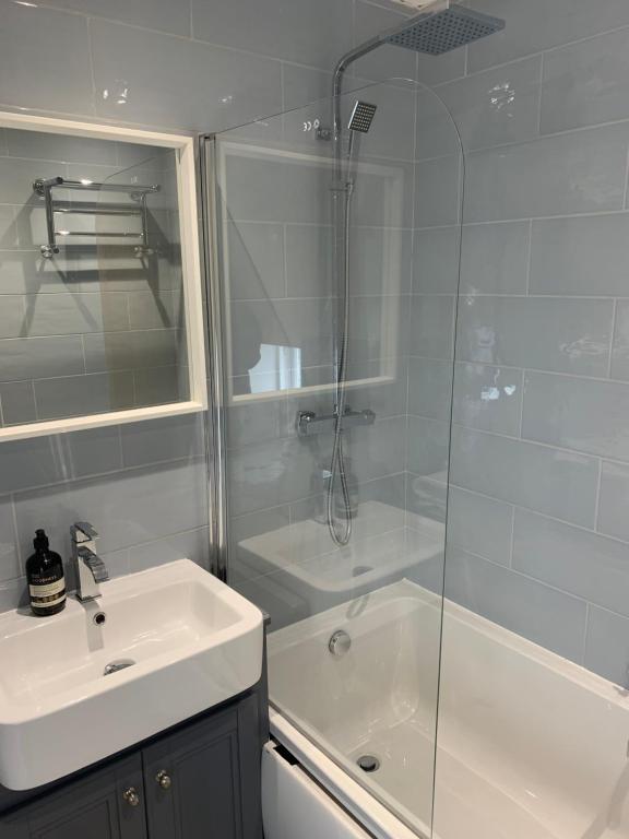 a bathroom with a shower and a sink and a tub at Lochindaal Hotel in Port Charlotte
