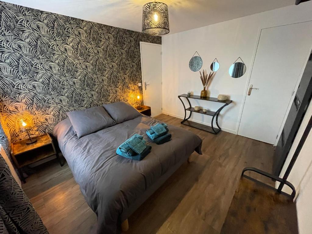 ein Schlafzimmer mit einem Bett mit zwei Handtüchern darauf in der Unterkunft Logement avec terrasse,4 pers, parking in Concarneau