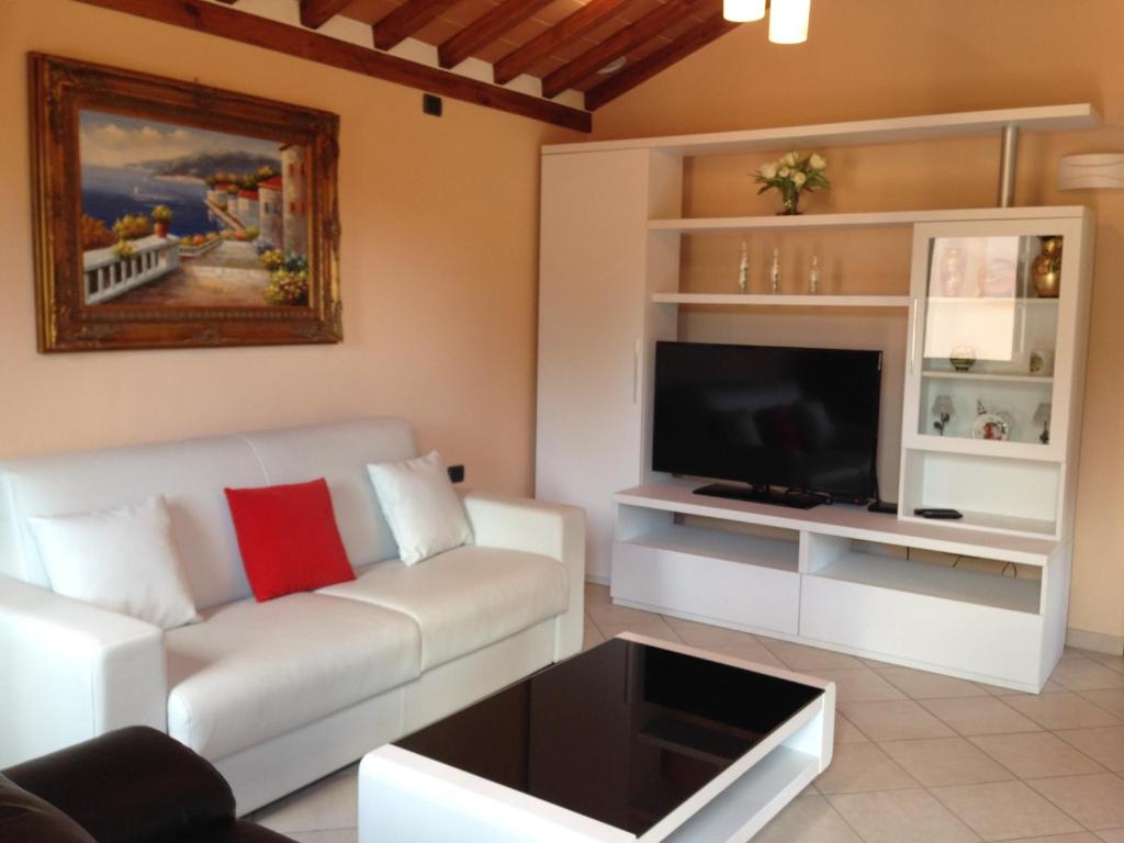 a living room with a white couch and a tv at Beautiful Tranquil Villa in Tuscany in Sarteano