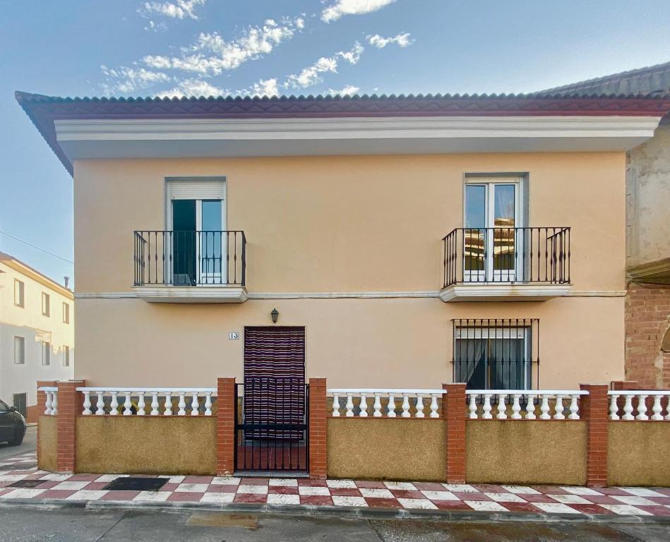 een huis met een poort en balkons bij Casa Nati in Alfarnate