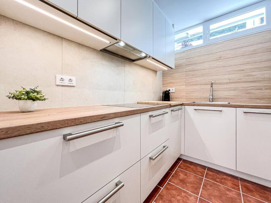 a kitchen with white cabinets and a sink at Apartament 'Es Botànic' in Blanes