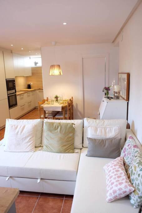 a living room with a white couch and a kitchen at Apartament 'Es Botànic' in Blanes