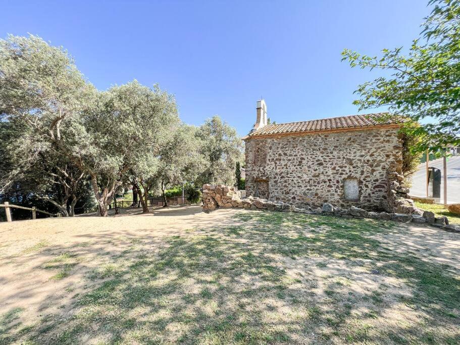 an old stone house with trees in front of it at Apartament 'Es Botànic' in Blanes