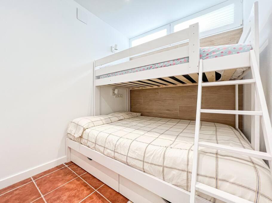 a white bunk bed in a white room with a ladder at Apartament 'Es Botànic' in Blanes