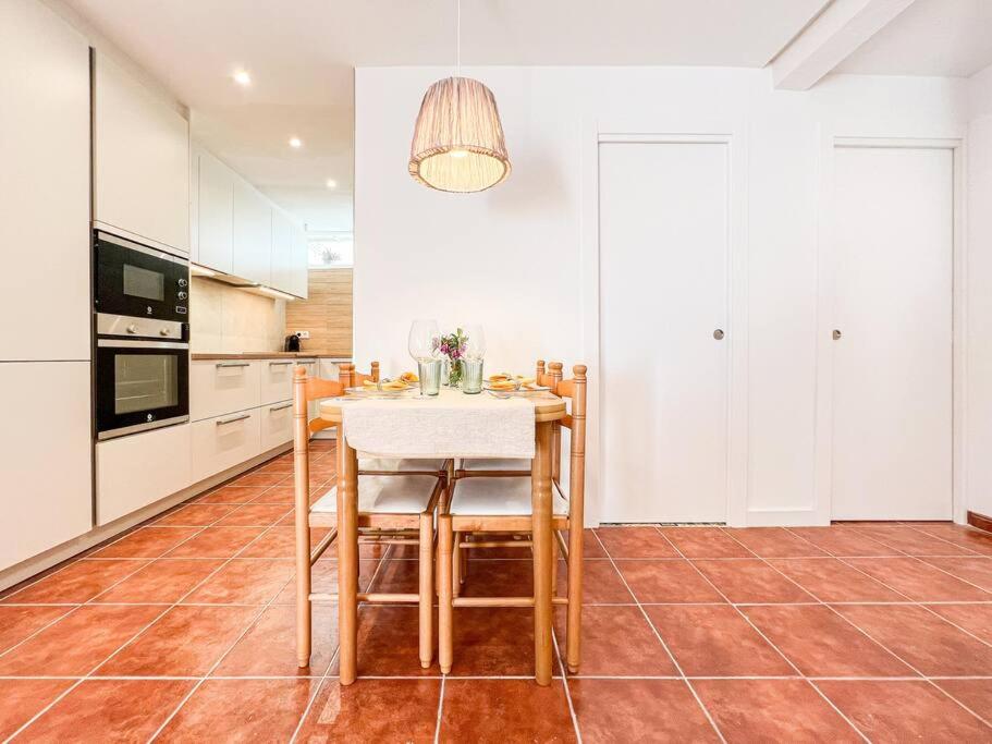 a kitchen with a table and some white cabinets at Apartament 'Es Botànic' in Blanes