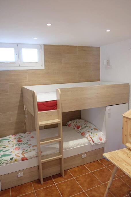 a bunk bed with a ladder in a room at Apartament 'Es Botànic' in Blanes