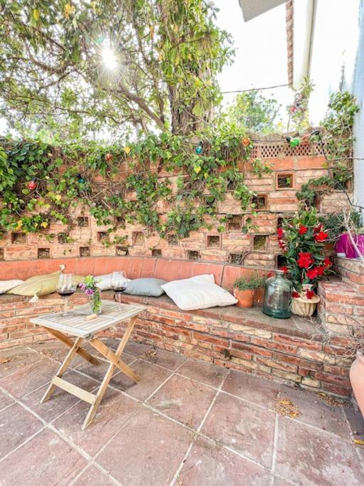 a brick wall with a bench with a table and a table sidx sidx at Apartament 'Es Botànic' in Blanes
