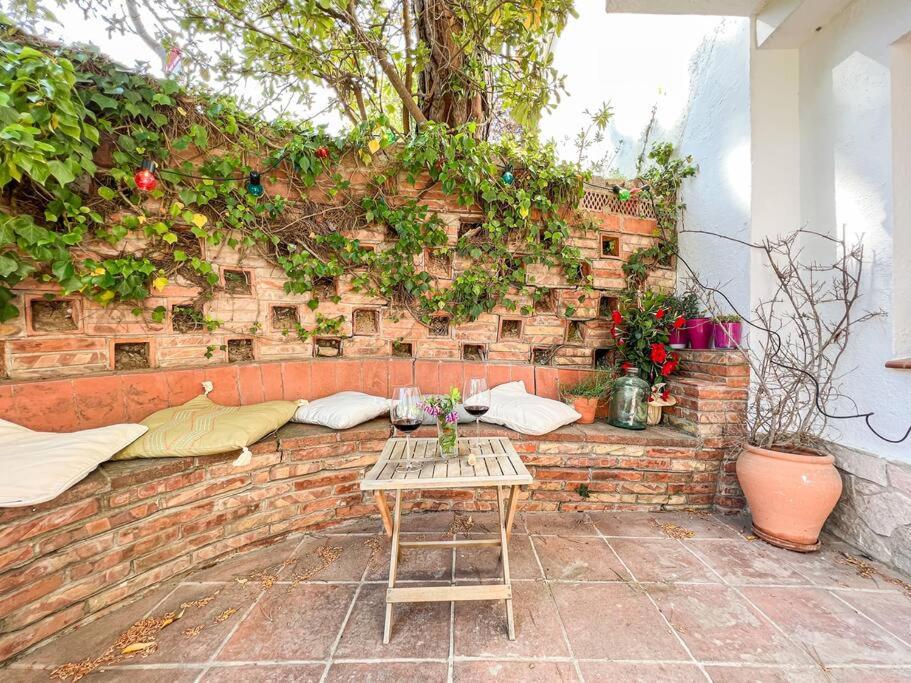 a brick wall with a bench and a table at Apartament 'Es Botànic' in Blanes
