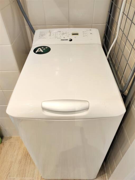 a white toilet in a corner of a bathroom at Apartament 'Es Botànic' in Blanes