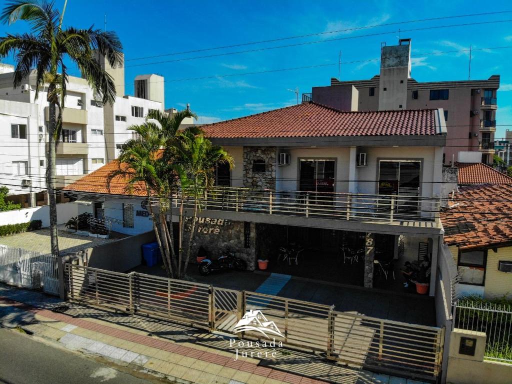 ein Haus mit einem Balkon vor einigen Gebäuden in der Unterkunft POUSADA JURERE in Florianópolis
