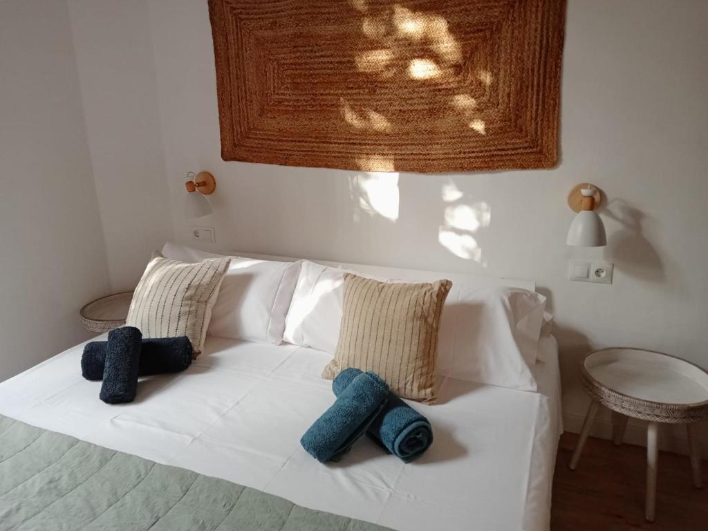 Una cama blanca con dos almohadas encima. en CAN LLAVI - LLAUT en Canet de Mar