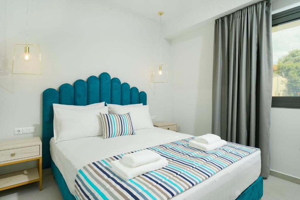 Schlafzimmer mit einem großen Bett mit blauem Kopfteil in der Unterkunft Miracle Suites by Klisma beach in Skala Kallirachis