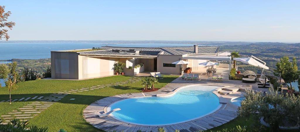 dom z basenem na podwórku w obiekcie Villa Luna Stunning Modern Villa Shared Infinity Pool, Big garden, Fantastic lake view,AC, w mieście Salò